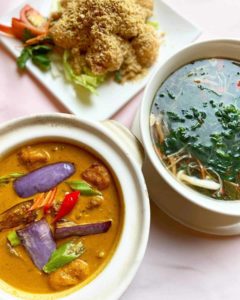 Three Chinese dishes with orange soup, spinach soup, and fried side dish
