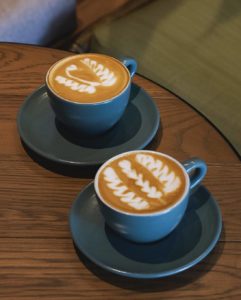 Two mugs of white coffee with latte art