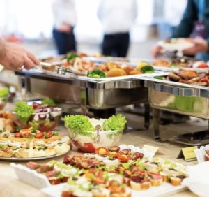 A buffet spread with a person serving