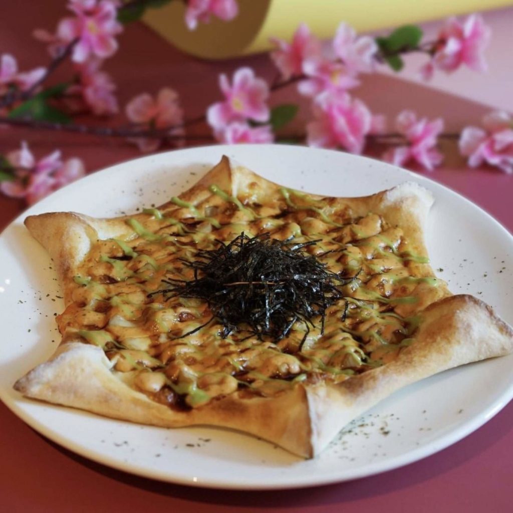 A star pizza with cheese toppings, garnish, and seaweed
