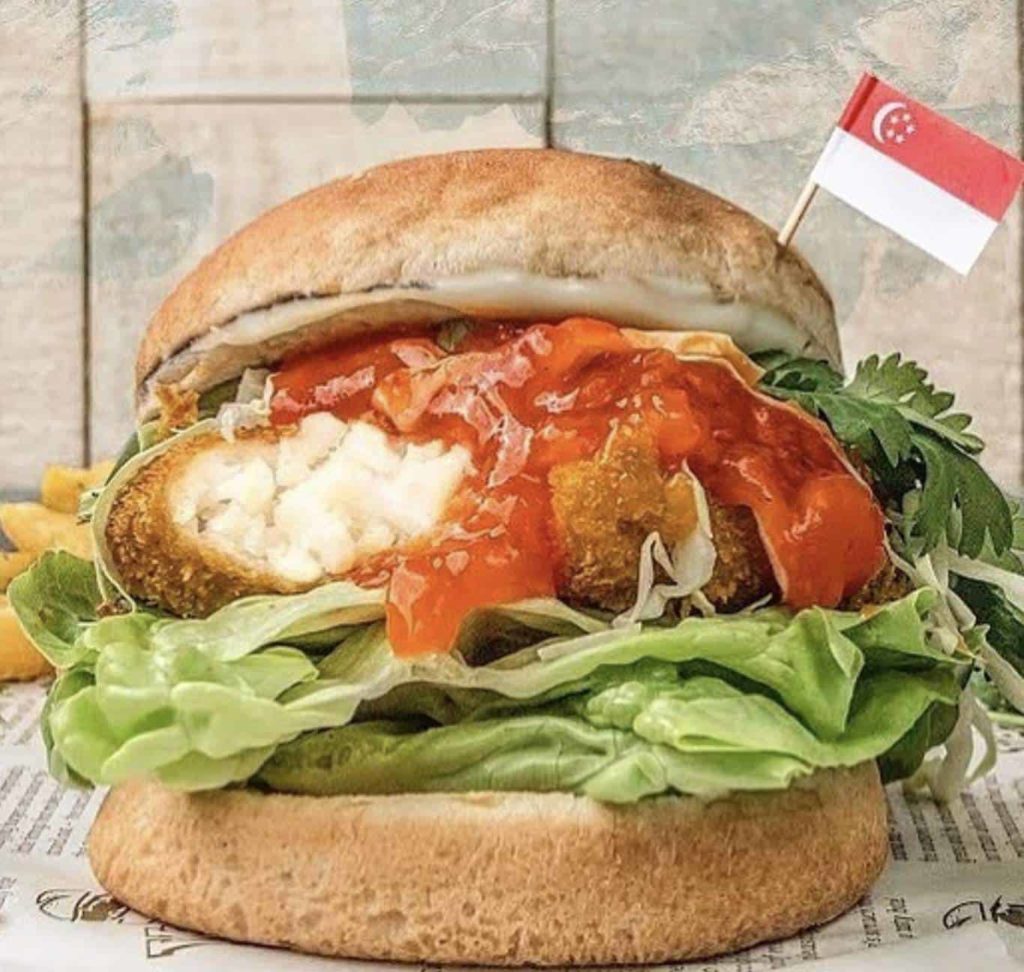 A vegan burger with mock crab, lettuce, sauce, and buns
