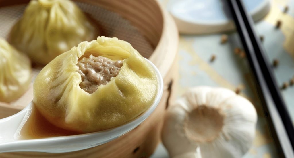 A close up shot of a half-eaten xiao long bao.