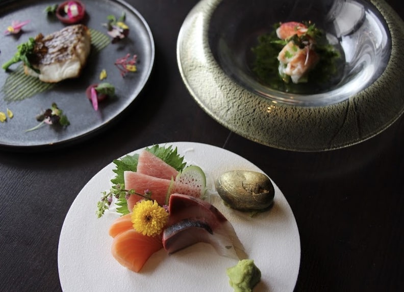 Three Japanese dishes plated with garnish