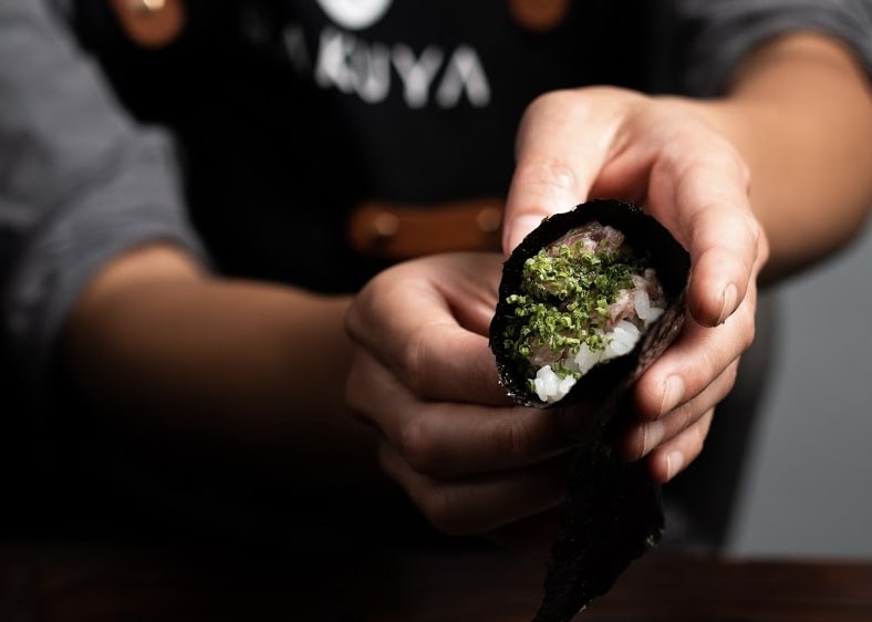 A chef holding a Japanese dish