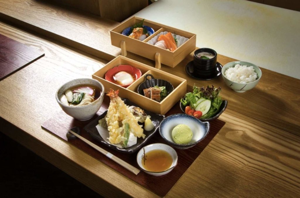 A complete Japanese lunch set with sushi, rice, meat, and soup