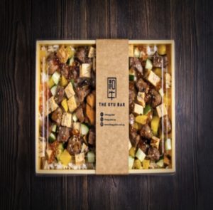 A bento box filled with Japanese wagyu, vegetables, and garnish